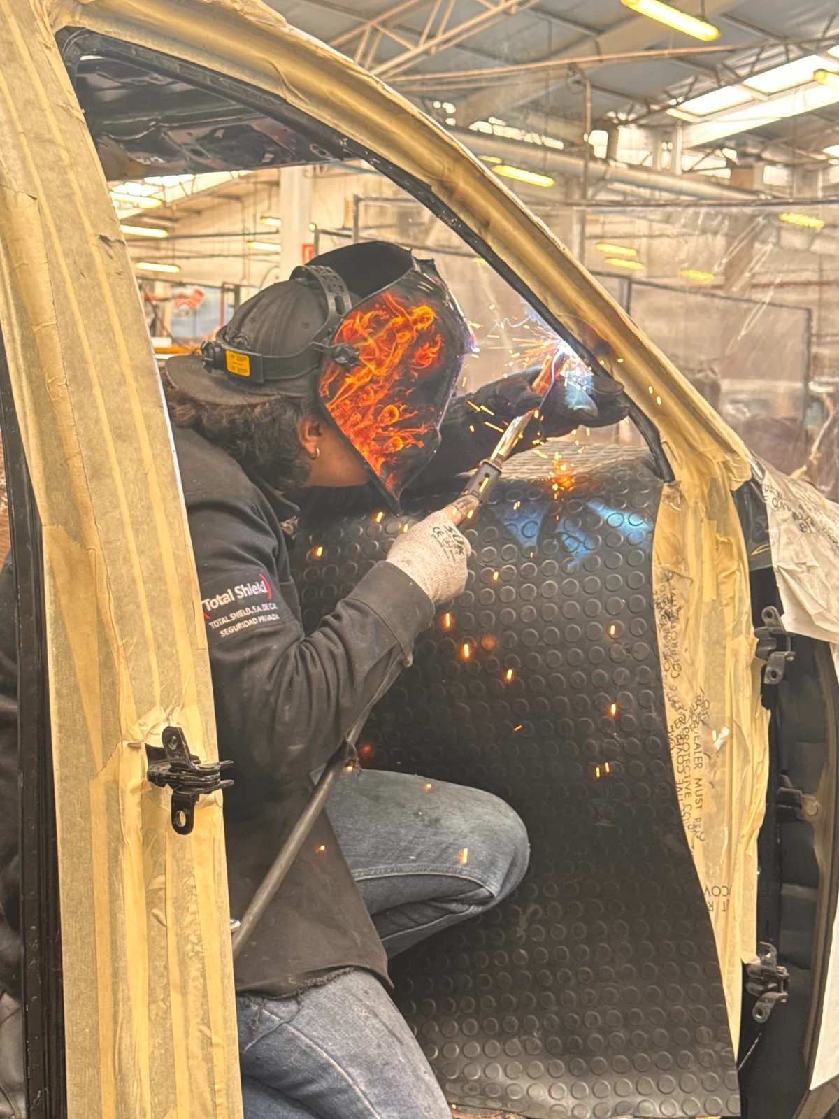 Técnico de Total Shield soldando placa balística